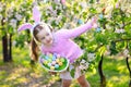 Child with bunny ears on garden Easter egg hunt