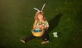 Child with easter eggs in basket outdoor. Boy on grass in park. Easter egg hunt. Fynny kids portrait. Cute bunny child Royalty Free Stock Photo