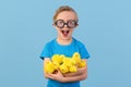 Child and Easter. Smiling blond boy, 6 years old, is holding a yellow eggs.