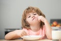 Child eat. Unhappy Caucasian child sit at table at home kitchen have no appetite. Upset little kid refuse to eat organic Royalty Free Stock Photo