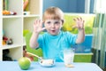 Child eating apple at dinner in nursery at home