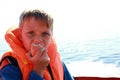 Child eating apple in life jacket on boat Royalty Free Stock Photo