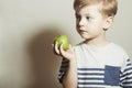 Child eating apple.Little Boy with green apple. Health food. Fruits. Enjoy Meal