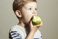 Child eating apple.Little Handsome Boy with green apple. Health food. Fruits