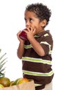 Child Eating Apple Picked from Grocery Bag Royalty Free Stock Photo