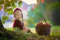 Child with apples in a village in autumn.