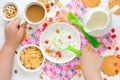 Child eating breakfast cereals with nuts, raisins, candied fruit Royalty Free Stock Photo