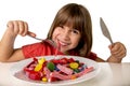 Child eating candy like crazy in sugar abuse and unhealthy sweet nutrition concept Royalty Free Stock Photo