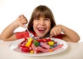 Child eating candy like crazy in sugar abuse and unhealthy sweet nutrition concept Royalty Free Stock Photo