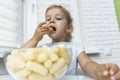 Child eating corn sticks at the kitchen table Royalty Free Stock Photo