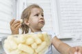 Child eating corn sticks at the kitchen table Royalty Free Stock Photo