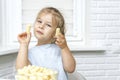 Child eating corn sticks at the kitchen table Royalty Free Stock Photo