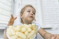 Child eating corn sticks at the kitchen table Royalty Free Stock Photo