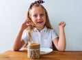Child eating crispbread peanut butter sitting at table in kitchen at home. Nutritious superfood vegan healthy lifestyle