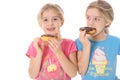 Child eating a doughnut looking at her sister