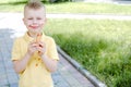 A child eating a French hot-dog and stains his clothes with a ketchup stain.The concept of cleaning stains on clothes.