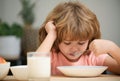Child eating healthy food at home. Unhappy child have no appetite. Upset little kid refuse to eat organic cereals with Royalty Free Stock Photo