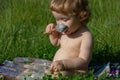 Child eating, nutrition concept. Spoon feeding baby. Funny child face. Feeding baby with big spoon outdoor on green Royalty Free Stock Photo