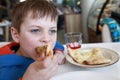 Child eating piece of four cheese pizza Royalty Free Stock Photo