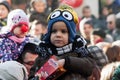 Child eating popcorn in a street full of people