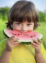 Child eating watermelon in the garden Royalty Free Stock Photo