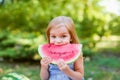 Child eating watermelon in the garden. Kids eat fruit outdoors. Healthy snack for children. 2 years old girl enjoying watermelon Royalty Free Stock Photo