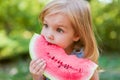 Child eating watermelon in the garden. Kids eat fruit outdoors. Healthy snack for children. 2 years old girl enjoying watermelon Royalty Free Stock Photo