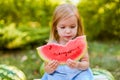 Child eating watermelon in the garden. Kids eat fruit outdoors. Healthy snack for children. 2 years old girl enjoying Royalty Free Stock Photo