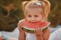 Child eating watermelon in the garden. Little girl playing in the garden holding a slice of water melon. Kid gardening Royalty Free Stock Photo