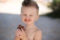 Child eats chokolate with full stength on a beach Royalty Free Stock Photo