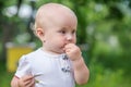 child eats green cherry berries in summer.portrait of todler against a backdrop of green trees. Danger of poisoning with unwashed