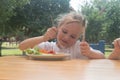 Child eats healthy food in cafe.