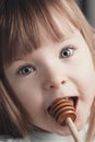 Close up portrait of funny lovely little girl eat honey Royalty Free Stock Photo