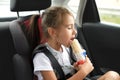 A child eats a hot dog in a car Royalty Free Stock Photo