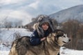 Child embraced husky dog. Boy in winter clothes with Siberian husky in snow. Royalty Free Stock Photo