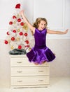 Child emotional cant stop her feelings. Girl in dress jumping. It is christmas. Day we have waited for all year finally