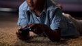 Child entertaining himself by playing video games on console, virtual dependency