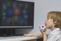 The child with enthusiasm looks at the monitor screen. An educational program or useful cartoons for smart children