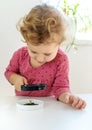 A child examines a plant under a magnifying glass. Selective focus. Royalty Free Stock Photo