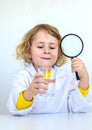 A child examines water with a magnifying glass. Selective focus. Royalty Free Stock Photo