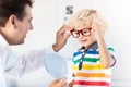 Child at eye sight test. Kid at optitian. Eyewear for kids.