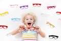 Child at eye sight test. Kid at optitian. Eyewear for kids.