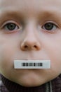 Child face with barcode sticker on mouth. Individual identifier.