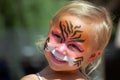 Child with face painted like tiger Royalty Free Stock Photo