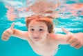 Child face underwater with thumbs up. Kid swimming in pool underwater. Child boy swim under water in sea. Summer kids Royalty Free Stock Photo