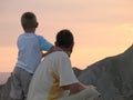 Child and father looking on sunset