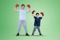 Child and father wearing boxing gloves on studio