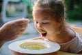 Child feading with soup at the restaurant garden Royalty Free Stock Photo