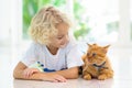 Child feeding home cat. Kids and pets Royalty Free Stock Photo