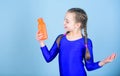 Child feel thirst after sport training. Kid cute girl gymnast sports leotard hold bottle for drink. Water balance and Royalty Free Stock Photo